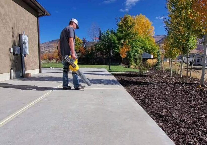 Poly-Lift worker prepping a driveway for sealing with mountains behind