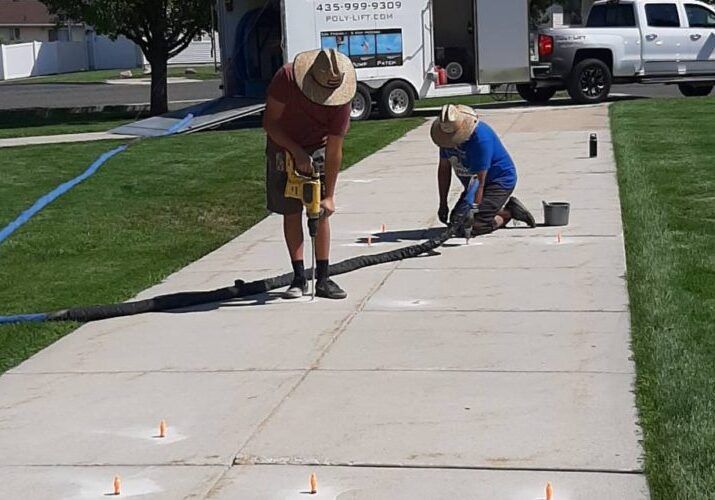 Poly-Lift crew injecting foam to lift a residential driveway in Cache Valley
