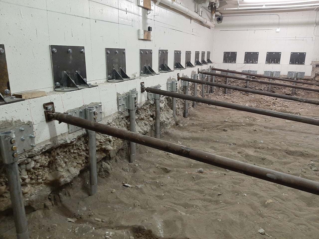 Rows of push piers installed under a Utah State University foundation
